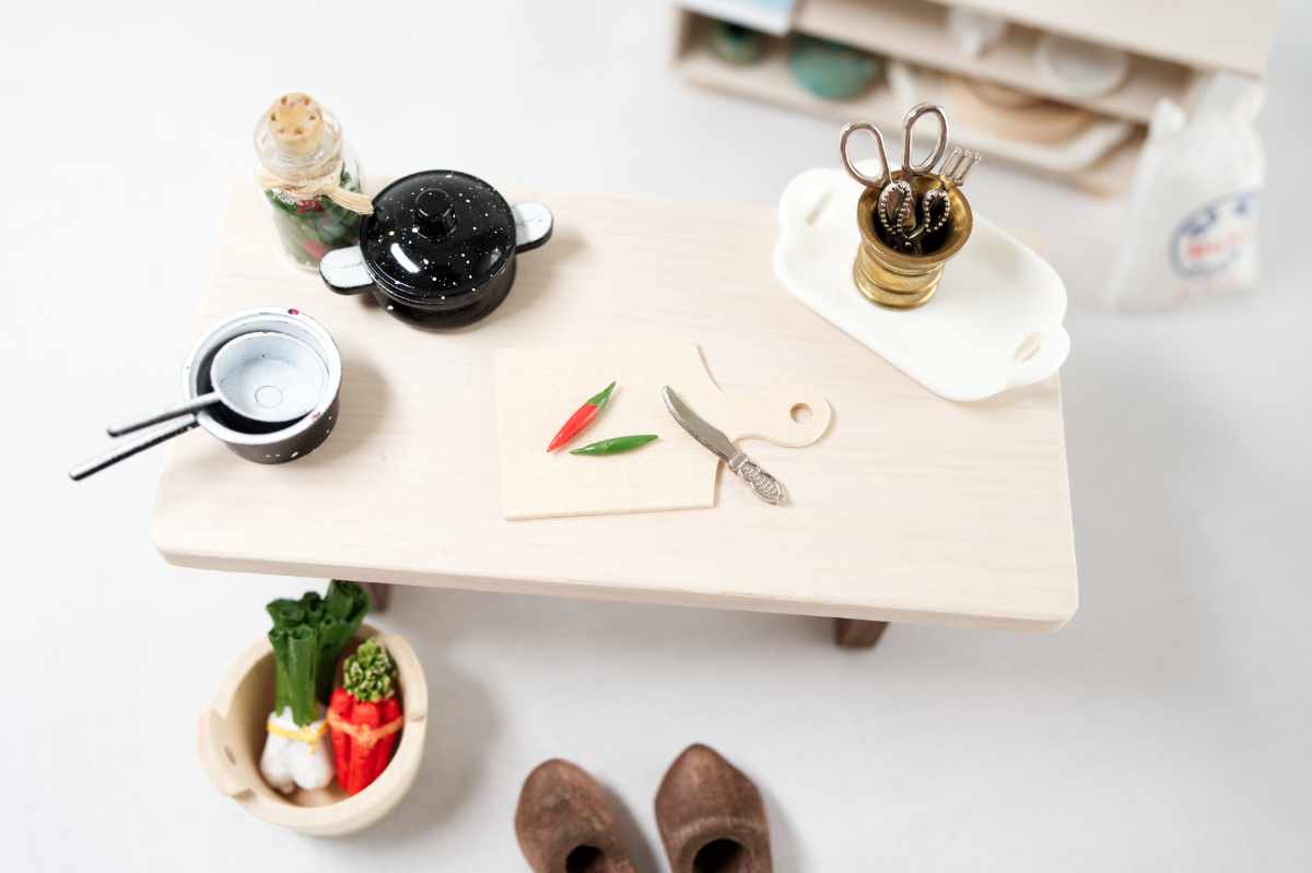 Wichteltür Zubehör Kategorie Küche: Tisch mit Schneidebrett, Gemüse, Messer, Töpfen, Küchenregal im Hintergrund