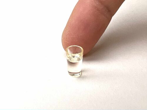 Wasserglas halb gefüllt mit Finger für Größenverhältnis