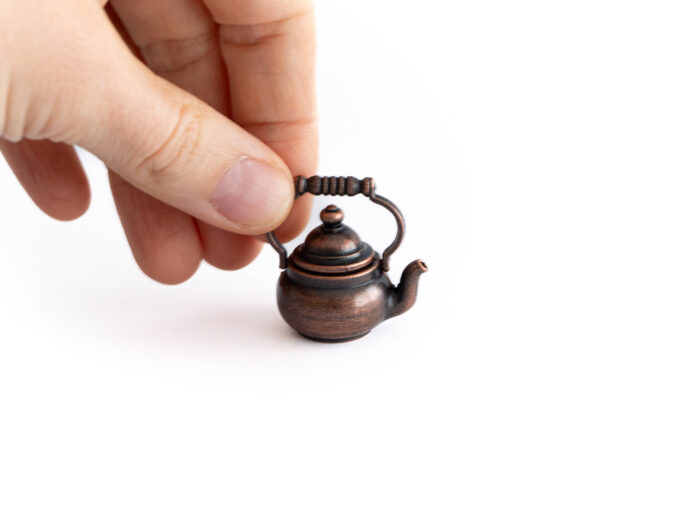 Teekanne antik mit Hand im Bild